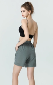 Detail view of high waist loose running shorts with a stylish cross-back sports top