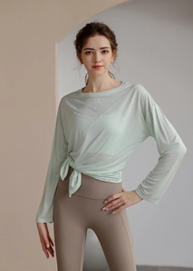 Détail du haut de yoga vert menthe avec tissu en maille respirant et nœud latéral
