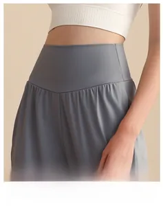 Dettaglio dei pantaloni yoga a vita alta con cintura a V per modellare l'addome