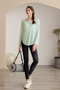 Détail d'un haut de yoga vert menthe à manches longues et d'un legging tie-dye sport