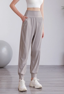 Dettaglio dei pantaloni sportivi grigi a vita alta con tasche e polsini elastici