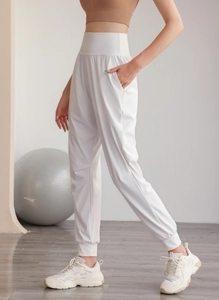 Dettaglio dei pantaloni da yoga bianchi a vita alta con polsini elastici e nylon liscio