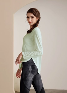 Détail du haut de yoga tencel vert menthe avec fentes latérales et legging marbre