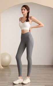 Zijaanzicht van witte sport-bh en blauwe high-waist legging met overslag taille