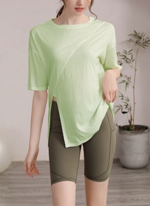 Détail du haut de yoga vert clair avec ourlet asymétrique et short de cyclisme olive