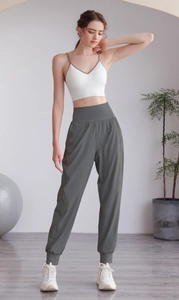 Dettaglio dei pantaloni fitness a vita alta a gamba larga con polsini elastici in nylon