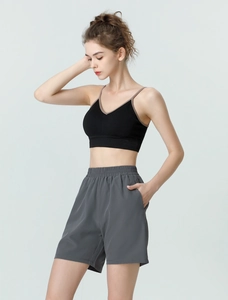 Detail of high-waisted gray sports shorts with side pockets and elastic waistband for gym