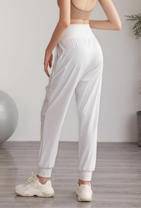 Dettaglio dei pantaloni sportivi in nylon bianco a vita alta con polsini elasticizzati
