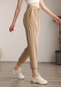 Detail of high waisted khaki joggers with elastic drawstring and side pocket for women