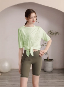 Détail du nœud avant sur un t-shirt de fitness vert clair respirant pour le yoga