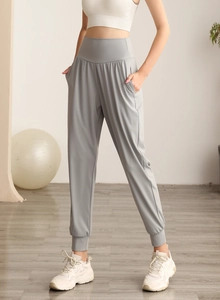 Dettaglio dei pantaloni sportivi grigi a vita alta con tasche laterali e polsini
