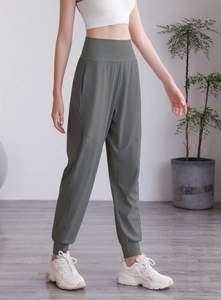 Détail du jogging vert olive à taille haute avec poignets élastiques et tissu mat séchant vite
