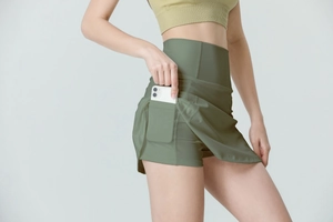 Détail d'une jupe-short de sport vert olive à taille haute avec poche latérale pour téléphone