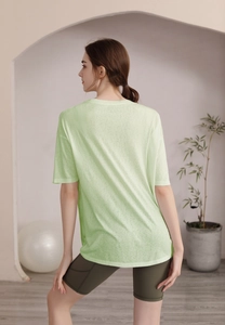 Vue arrière d'un t-shirt de yoga vert clair ample et d'un short de cyclisme taille haute olive