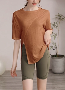 Vue détaillée du haut de yoga marron respirant avec ourlet croisé asymétrique unique