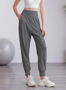 Dettaglio dei pantaloni sportivi grigio scuro a vita alta con elastico e tasche laterali