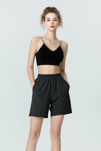 Detail of high-waist black sports shorts with elastic waistband and side pockets
