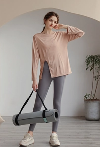 Haut de yoga rose ample en tencel avec fentes latérales dans un studio minimaliste