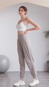 Dettaglio dei pantaloni sportivi da yoga a vita alta per donna in una palestra moderna