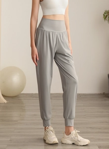 Dettaglio dei pantaloni sportivi grigio chiaro a vita alta in nylon con fondo elasticizzato