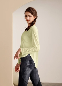 Détail d'un haut de yoga jaune avec fentes latérales et legging tie-dye assorti