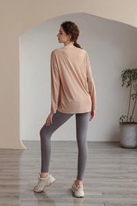 Vue arrière du haut de yoga ample en tencel avec un legging gris foncé et baskets