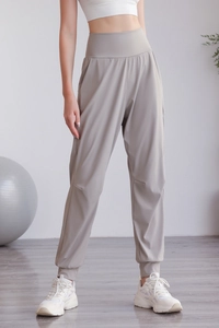 Dettaglio dei pantaloni sportivi a vita alta con tasche laterali e polsini per yoga e fitness