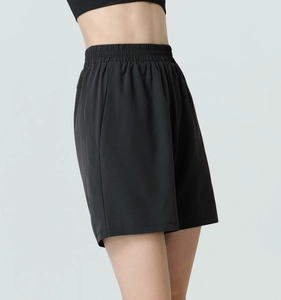 Detail of high waist black sports shorts featuring elastic waistband and side pockets