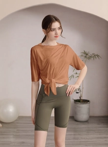Détail du haut de sport en tencel avec nœud à la taille et short cycliste avec poches