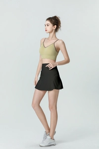 Détail de la jupe de tennis noire taille haute avec caraco de sport vert olive col V