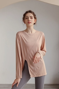 Détail d'un haut de yoga rose poudré à manches longues avec fente et tissu texturé