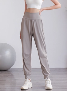 Dettaglio dei pantaloni sportivi grigi a vita alta con polsini per fitness e yoga