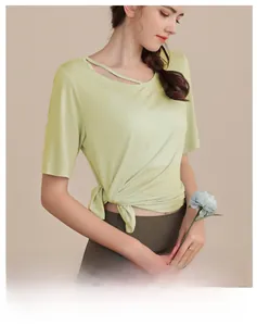Detail of light green yoga top with asymmetric shoulder strap and side tie waist detail