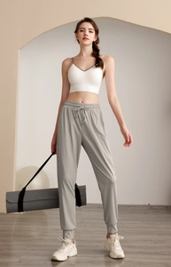 Detailed view of high-waist loose joggers with white sports bra and drawstring waist