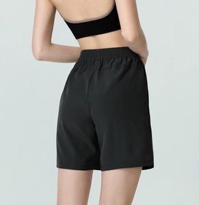 Rear view of black loose-fit high-waisted sports shorts with elastic waistband on model