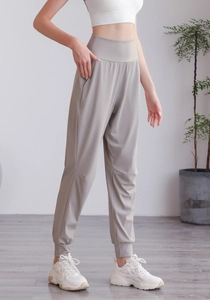 Dettaglio dei pantaloni jogger a vita alta con polsini affusolati e tasche in nylon kaki