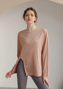 Détail du haut de yoga rose avec ourlet fendu asymétrique et tissu fluide et doux