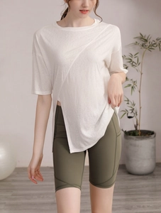 Détail d'un t-shirt de sport blanc à ourlet irrégulier et d'un short cycliste olive