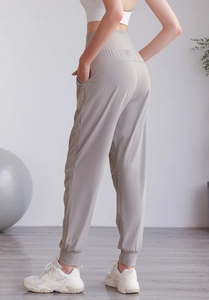 Dettaglio dei pantaloni sportivi a vita alta con tasche laterali e polsini a costine