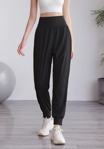 Dettaglio dei pantaloni yoga neri a vita alta con polsini elastici e vestibilità ampia