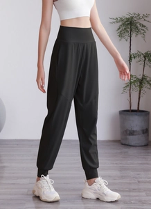 Détail du jogging noir taille haute montrant la ceinture large et les poignets élastiques