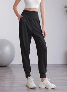 Dettaglio dei pantaloni sportivi neri a vita alta con tasche laterali e fascia larga