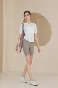 Détail du t-shirt de yoga blanc translucide et du short de sport moulant avec poches latérales