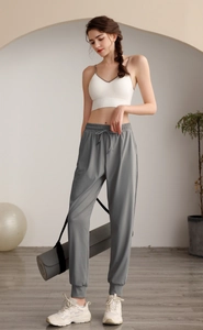 Detail of high waist grey joggers with drawstring and white sports bra for yoga and gym