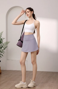Close-up of high-waisted lavender sports skirt paired with a white yoga tank top
