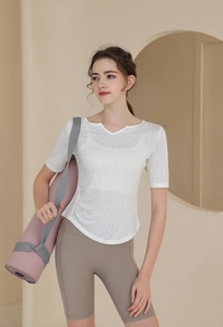 Détail d'un haut de yoga blanc respirant et d'un short de sport marron pour femmes