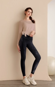 Détail du haut de yoga beige en mesh noué à la taille et leggings gris marbré