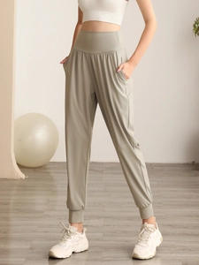 Dettaglio dei pantaloni da yoga a vita alta con tasche laterali e polsini elastici