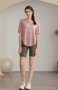 Close-up of pink Tencel yoga top with cut-out neckline and olive green cycling shorts
