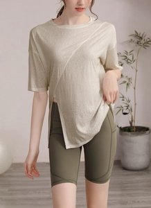 Détail de l'ourlet fendu du t-shirt beige et short de yoga vert avec poches latérales